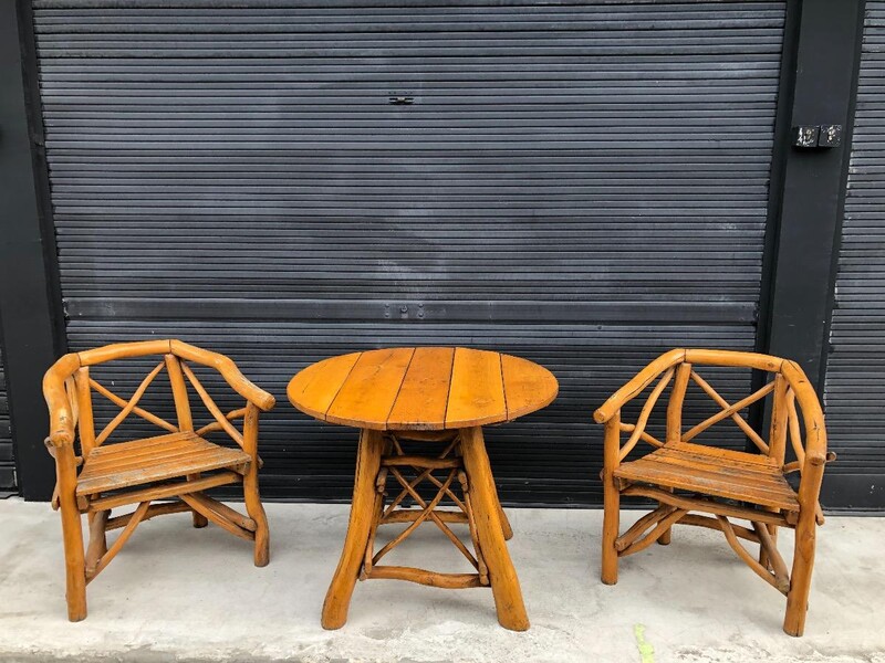 garden furniture in varnished raw wood logs , table and two armchairs